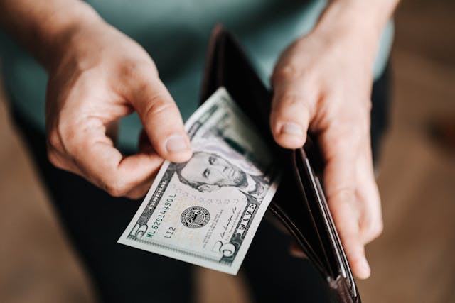 person taking money out of wallet