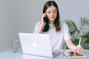 person talking on the phone and taking notes on their iPad