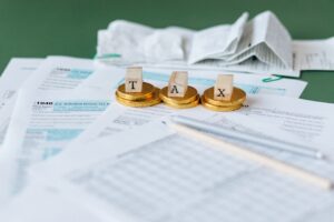 tax forms spread out with the word tax spelled in block letters on top